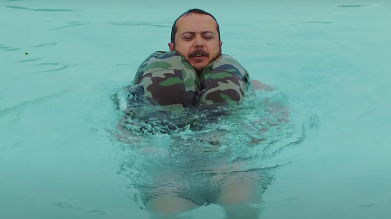 Man floating on water with pants as floatation device