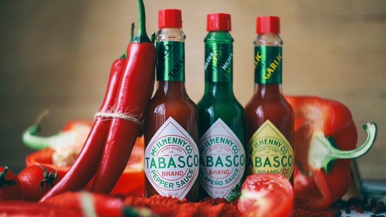 tabasco bottles next to red peppers