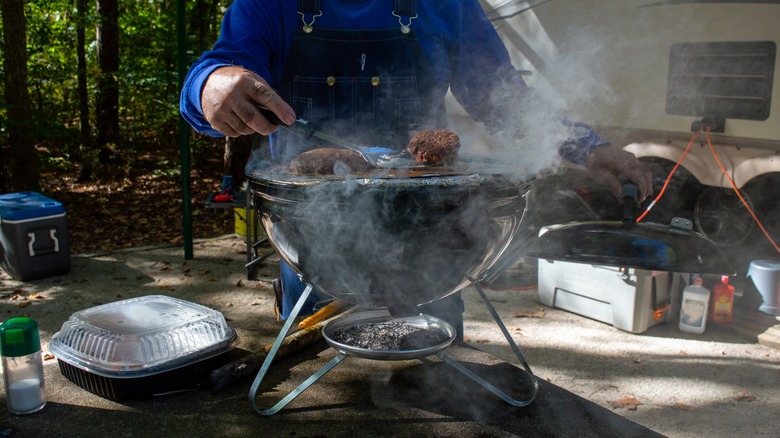 Man grilling on small portable charcoal grill 