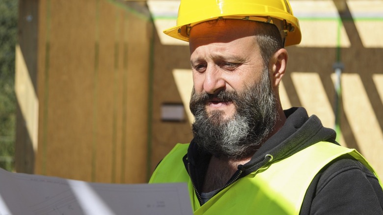 Construction worker looking at paper