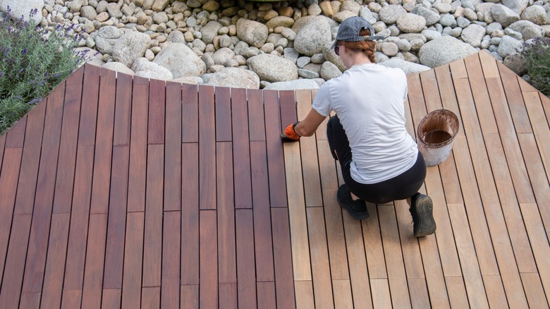 Woman sealing hardwood deck