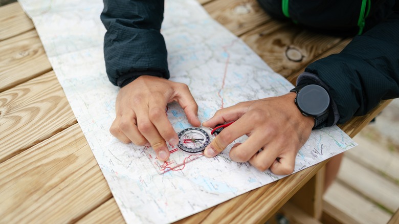 Camper orienting a map and compass 