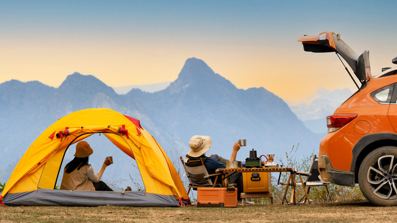 Friends camping in a tent over looking a mountain