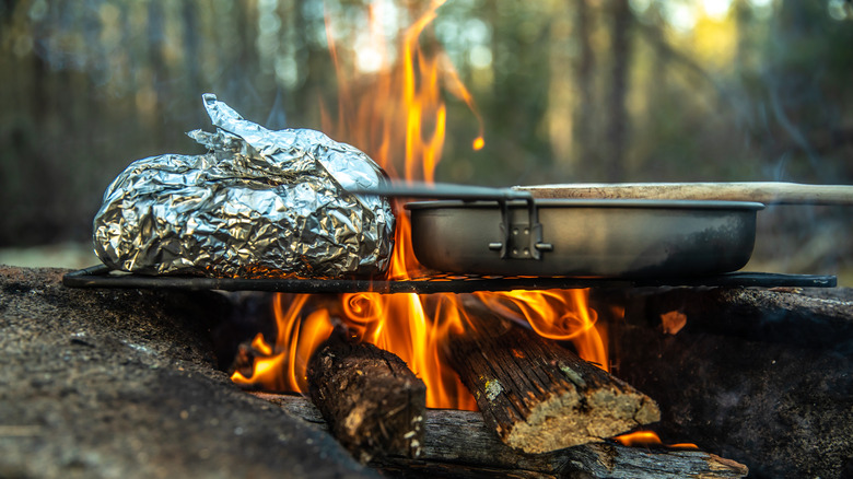 Foil food and a pot over a campfire