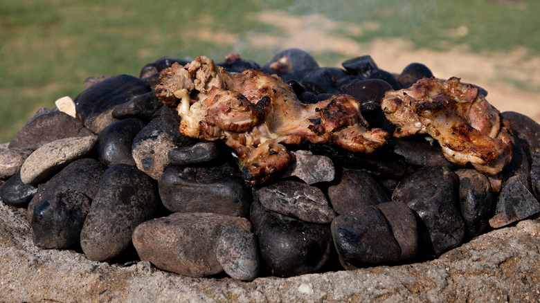 meat cooking on hot stones