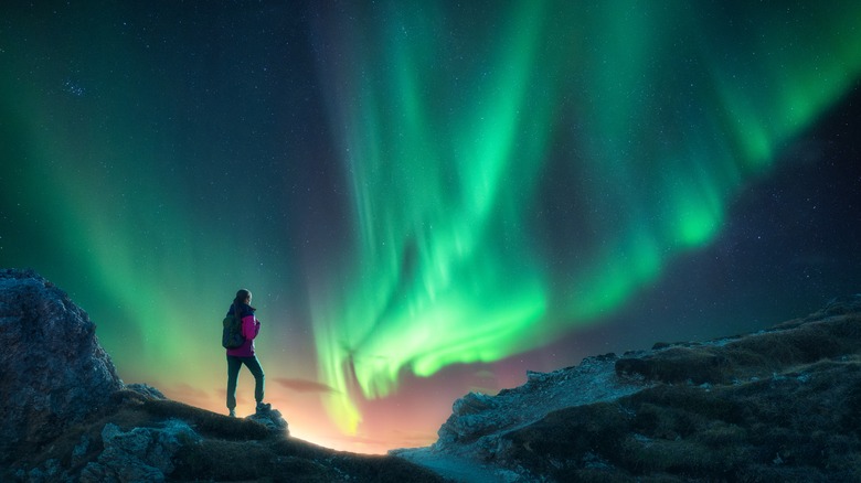 hiker viewing northern lights