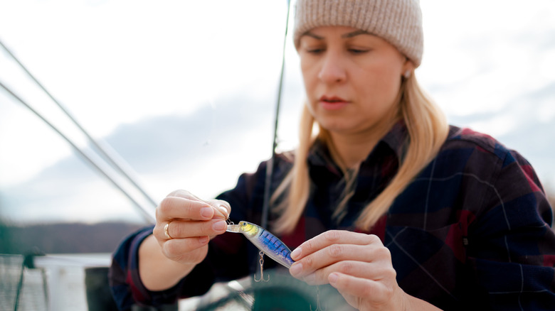 Angler holding and looking at lure