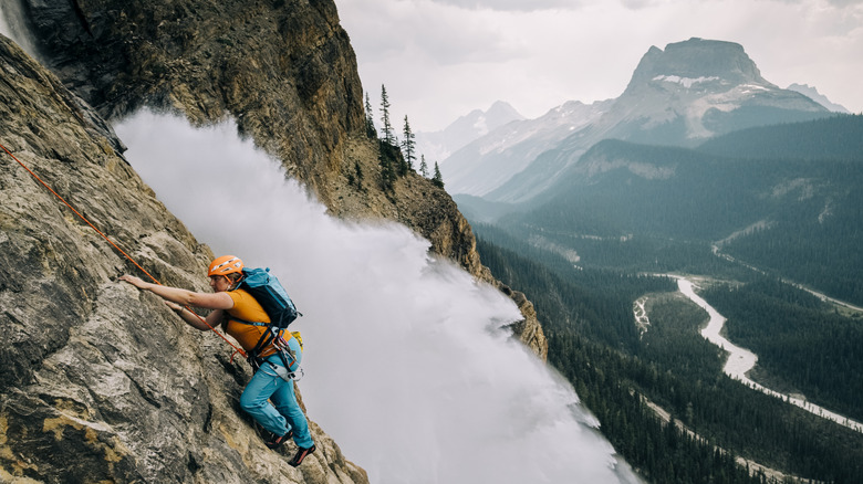 Person scaling mountain