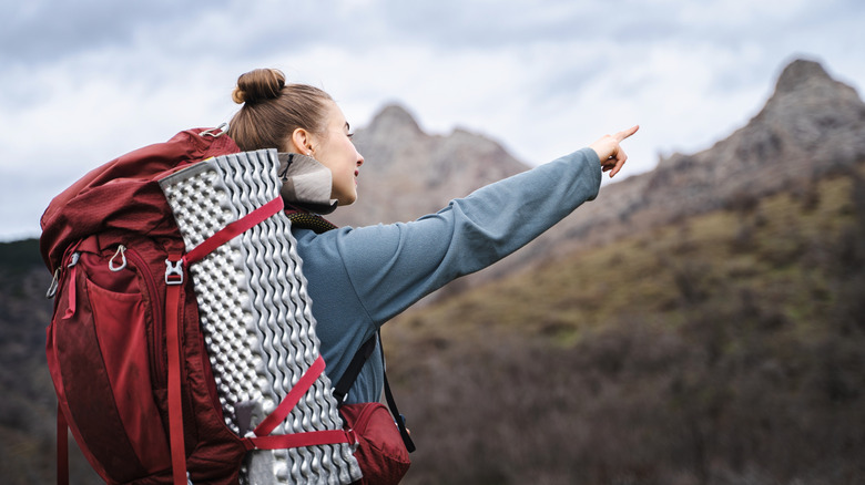 Female hiker looking into distance and pointing