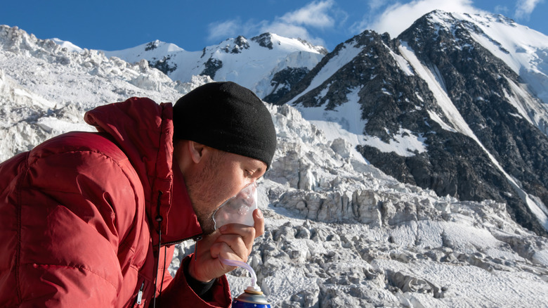 Person using oxygen on at high-altitude mountain