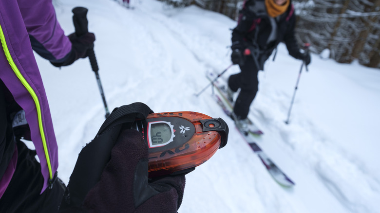 Skiers checking their avalanche beacons 