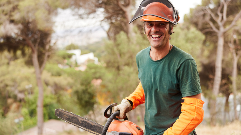Smiling arborist with a chainsaw
