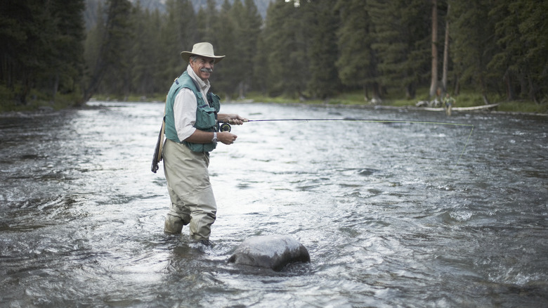Man happily fly fishing in river 