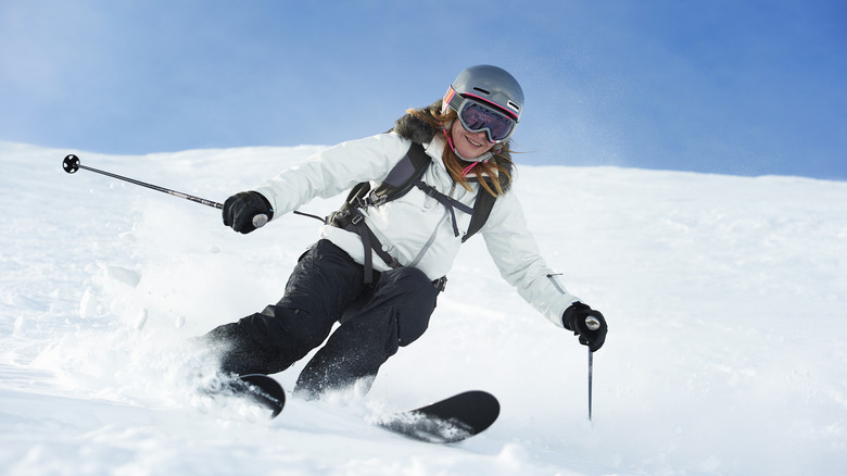 Woman skiing down snowy slope 