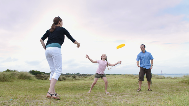 Family playing frisbee outside