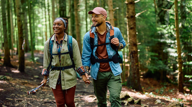 Smiling couple hiking in forest
