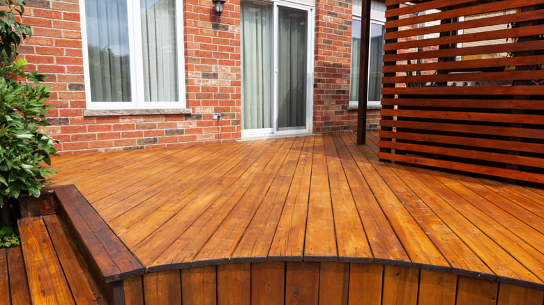 wooden deck outside of brick home