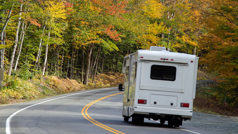 RV driving through forest in autumn