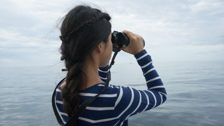 girl whale watching with binoculars