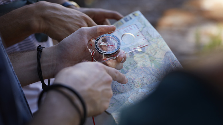 Hikers marking progress on map