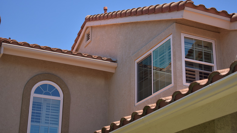 A house with tile roof shingles and stucco siding