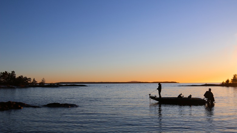 angler fishing on a boat near rocks