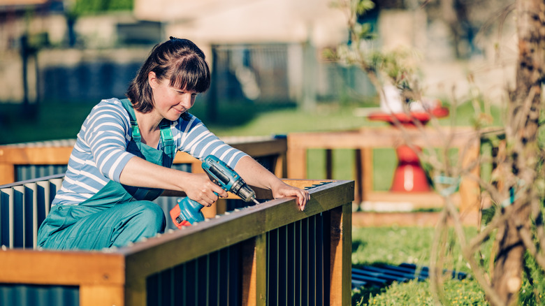 Young woman building a raised garden bed