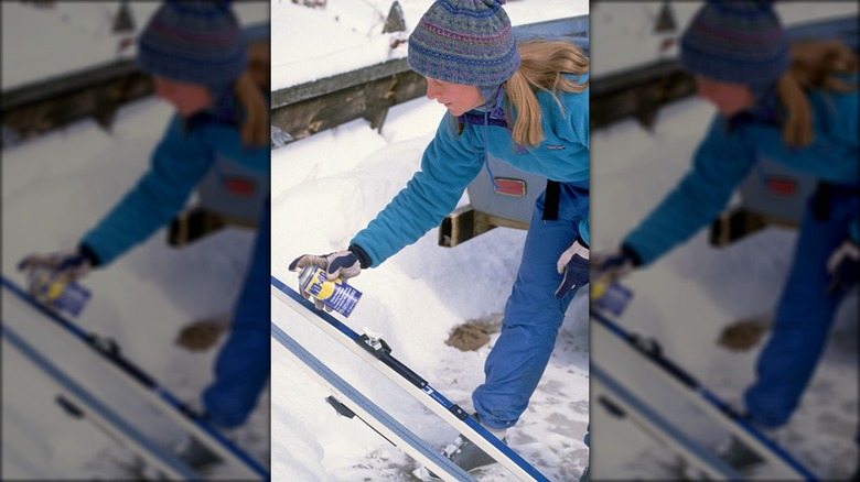 Woman putting WD-40 on skis