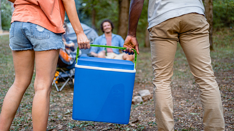 Couple holding a blue cooler