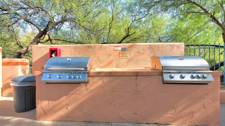 Grills outside next to a fire extinguisher