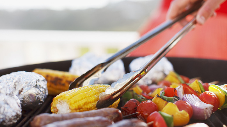 Using long tongs to grill