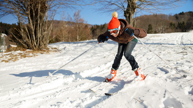 A person learning to ski on a snowy slope