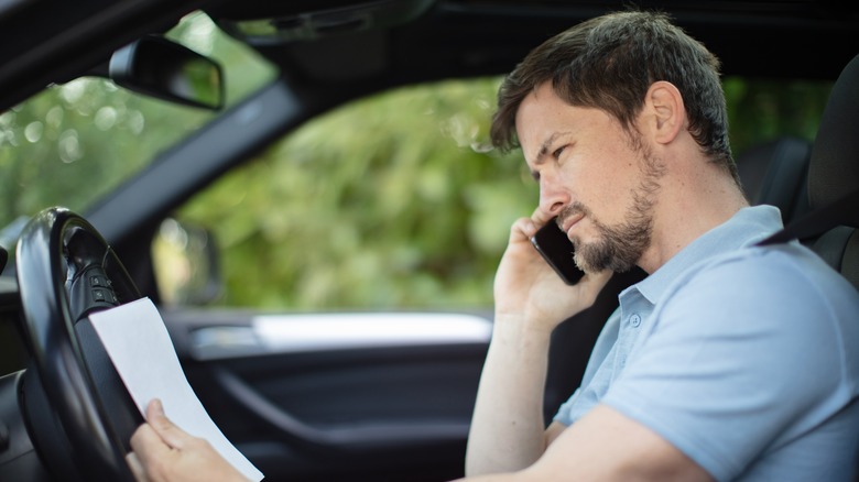 Man in car on his phone, calling in accident