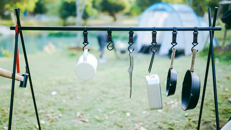 Camp cooking utensils hanging on rack