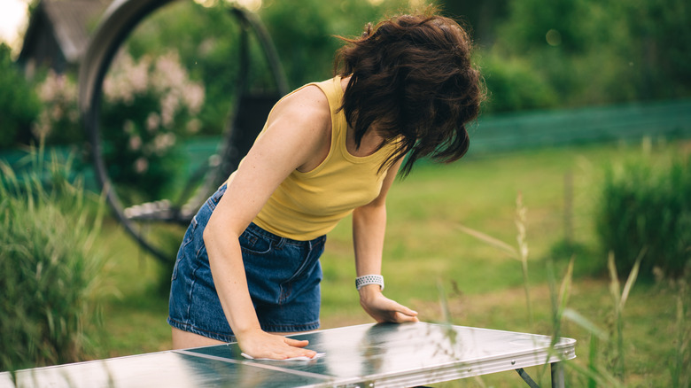 Woman cleaning patio table