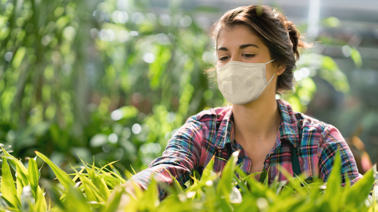 Woman wearing mask while gardening