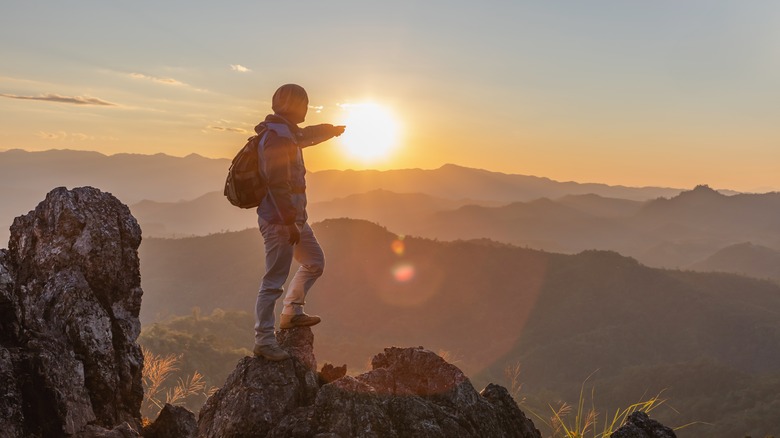 Hiker enjoying sunset from mountain top