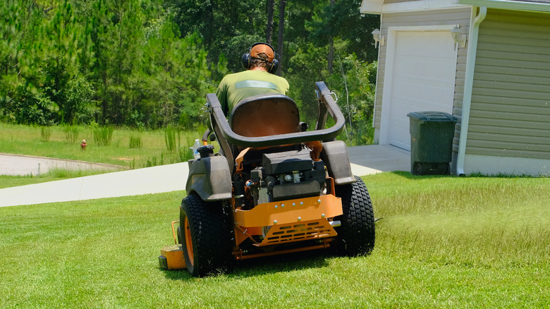 Man seated and powering a lawn mower