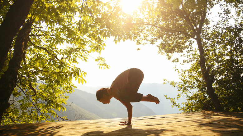 Woman doing yoga on deck outside