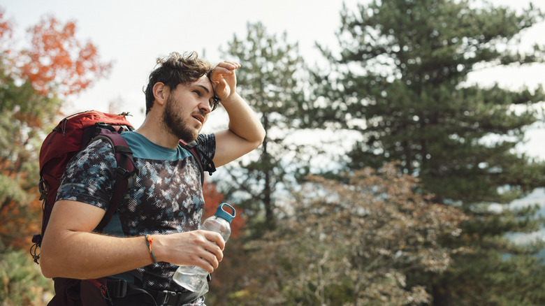 Exhausted hiker with hand on head 