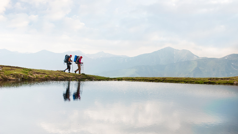 two trekkers near an alpine lake