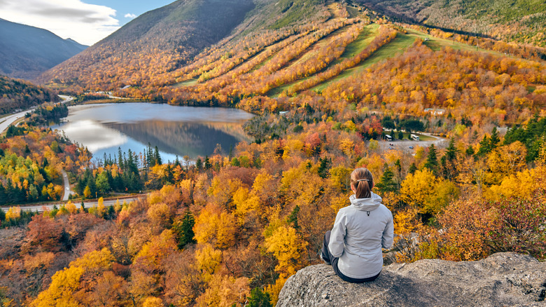 Woman seated on edge of White Mountains in fall 
