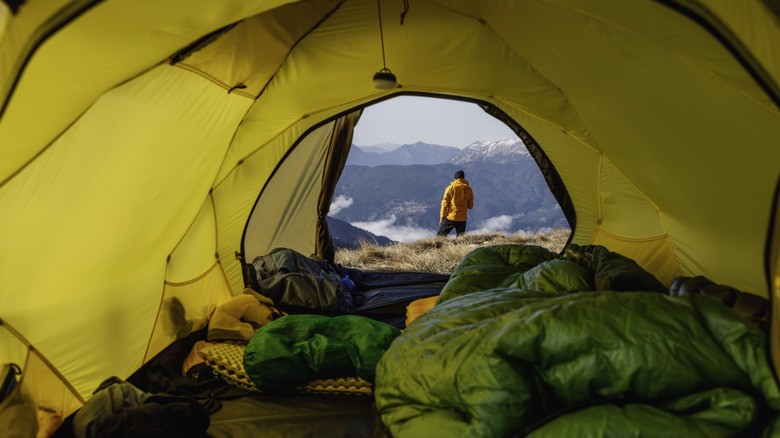 Camper standing outside of tent