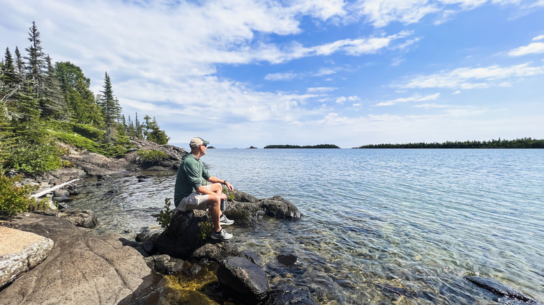 Man sitting on rock looking at Lake Superior