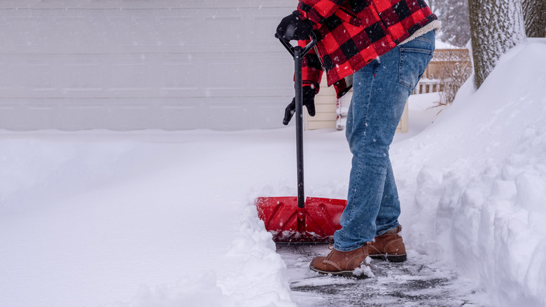 Man shoveling snow with red shovel