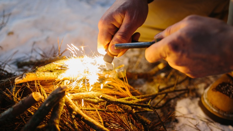 Person starting campfire