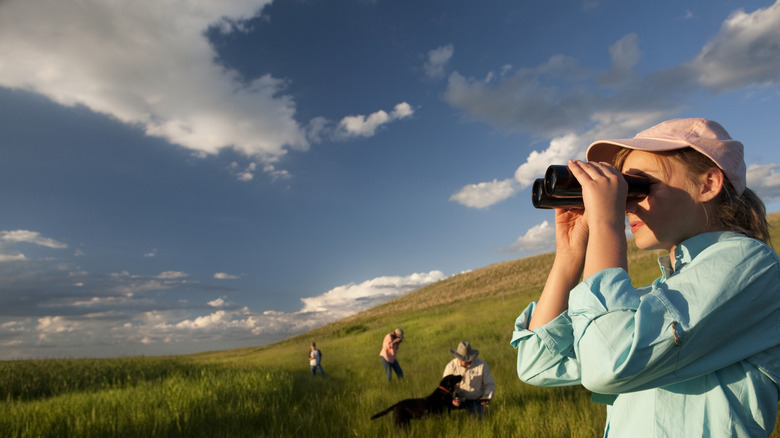 Female birder looking out across a meadow