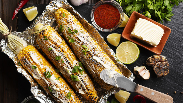 Corn with butter, herbs, and spices on table