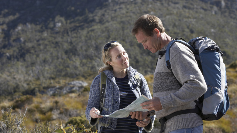 Male and female hiker looking at information
