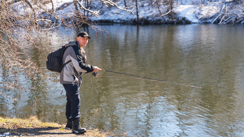 Man fishing in winter, looking at camera